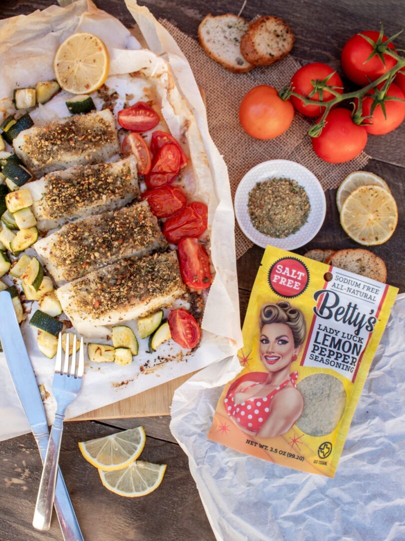 A table with some food and a box of lemon pepper.