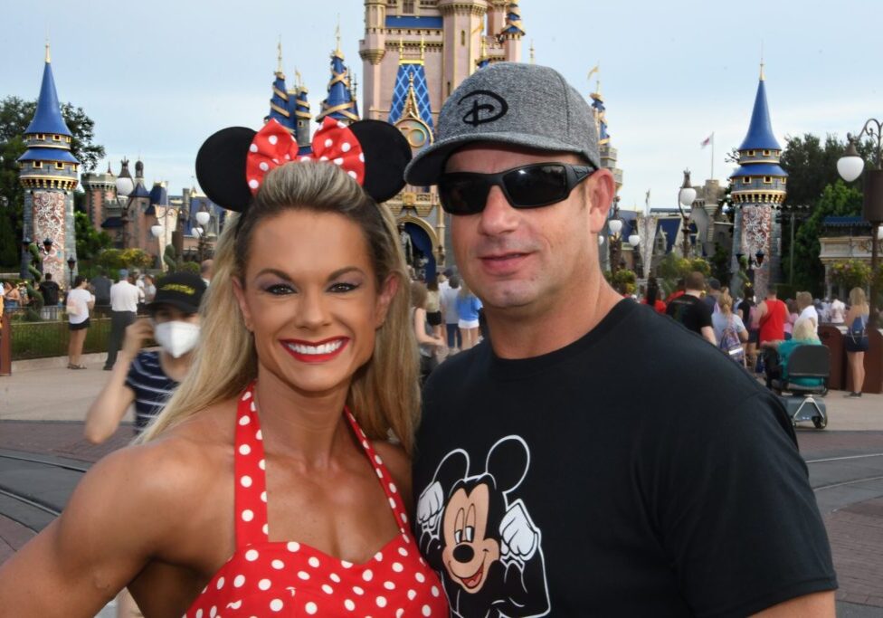 A man and woman posing for the camera in front of a castle.