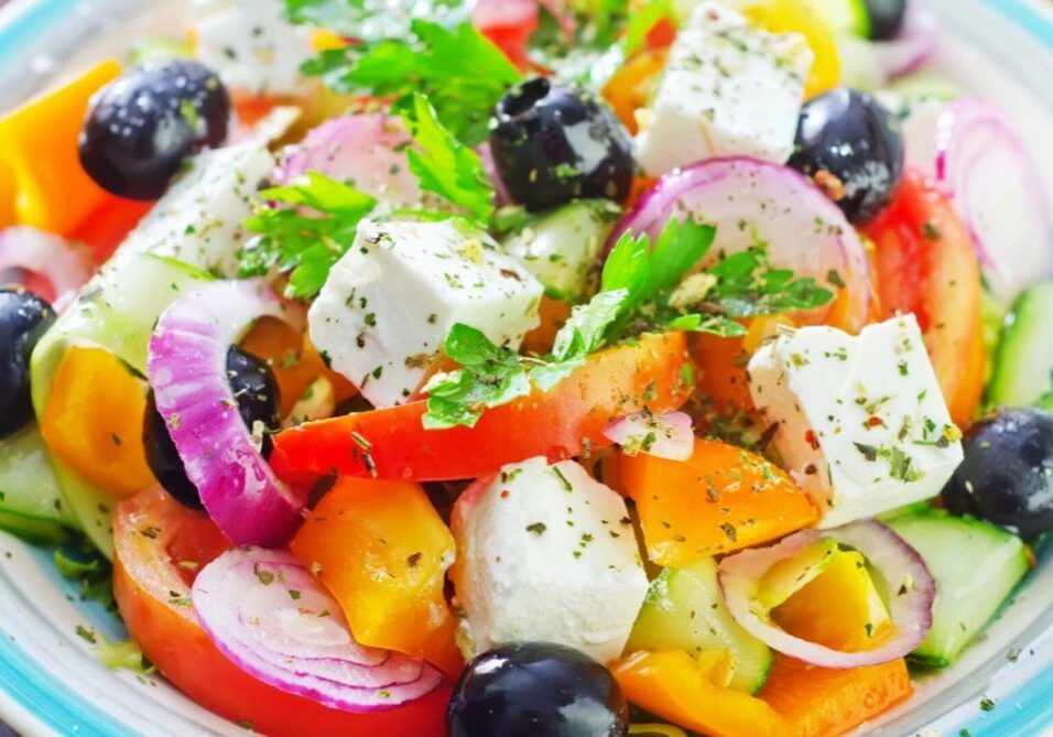 A salad with tomatoes, onions and olives.